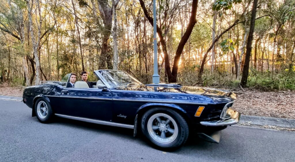 Students in dark blue Ford Mustang rented for a school formal